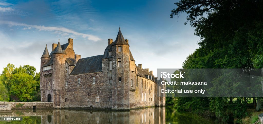 view of the historic Chateau Trecesson castle in the Broceliande Forest with reflections in the pond Campeneac, Brittany / France - 26 August 2019: view of the historic Chateau Trecesson castle in the Broceliande Forest with reflections in the pond Foret de Paimpont Stock Photo