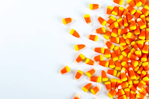 istock Bright colorful candy corn scattered on textured surface as symbol of autumnal holidays. 1180960859