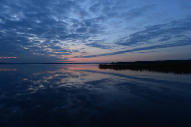 istock Twilight blue sky in clouds reflected on lake water at sunset in the autumn evening 1180961392