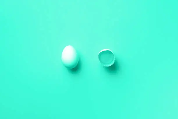 Photo of Food concept with white chicken eggs on trendy gradient background. Top view. Creative pattern in minimal style. Mint green and turquoise color. Flat lay.