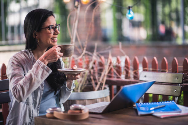 istock Beautiful female student drinking coffee and working in cafeteria. 1180967044