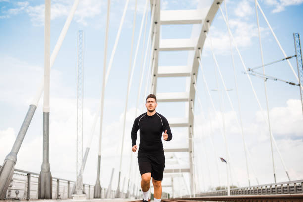 istock Photo of an athletic man stretching after exercise. 1180968015