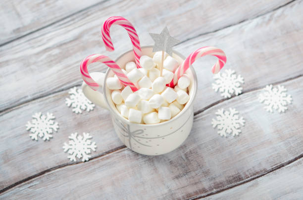 istock New Year or Christmas concept. Composition with marshmallows and candy canes on a wooden background. 1180968101