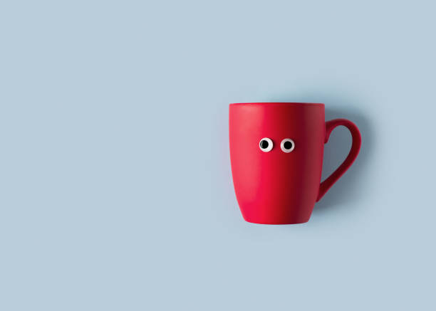 istock Funny googly eyes red cup flat lay on blue background 1180973088
