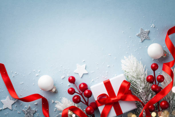 istock Christmas card. Fir tree branches, holiday decorations and gift or present box on blue background top view. 1180973108
