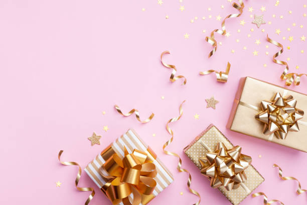 istock Christmas background. Golden gift or present boxes and star confetti on pink top view and flat lay. 1180973321