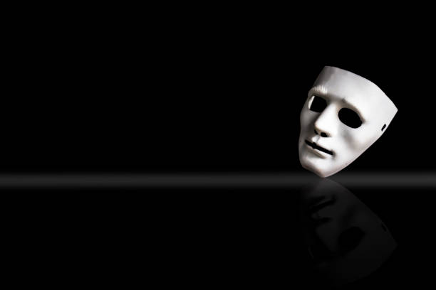 istock White-colored plastic face mask isolated on a black background along with its reflection. 1180974325