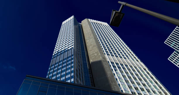 istock Perspective skyscraper with a modern angular streetlight in front of a dark blue sky 1180976411