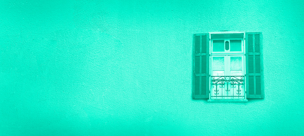 Old painted windows on mint color concrete wall. Banner with copy space. Trendy green and turquoise color. Pop art concept, greek style window.