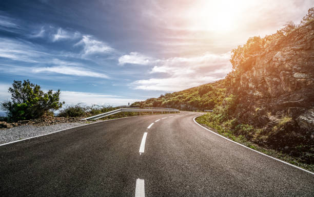 istock Empty long road on a sunny summer day at bright sunset 1180978720