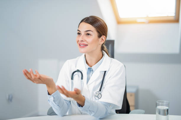 istock Beautiful young female doctor talking - greeting a patient. 1180979078