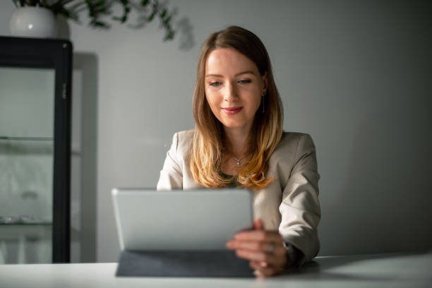 istock Young woman typing on digital tablet in her office 1180980892