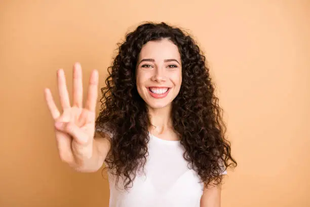 Closeup photo of amazing lady raising hand showing four fingers starting, countdown wear white casual outfit isolated beige pastel color background