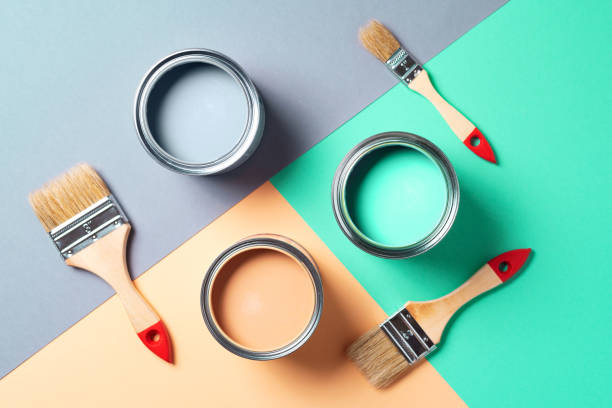 istock Metal paint cans and paint brushes on multicolor background. Top view. Copy space. Trendy green color concept 1180989914