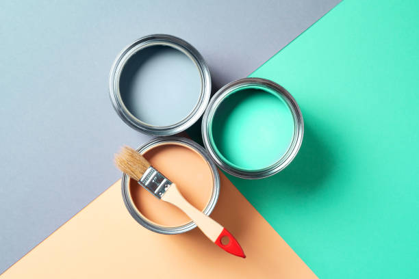 istock Metal paint cans and paint brushes on multicolor background. Top view. Copy space. Trendy green color concept 1180989957