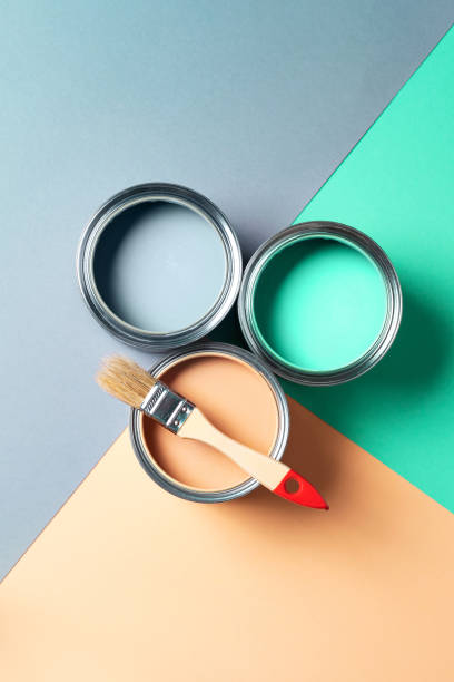 istock Metal paint cans and paint brushes on multicolor background. Top view. Copy space. Trendy green color concept 1180989959