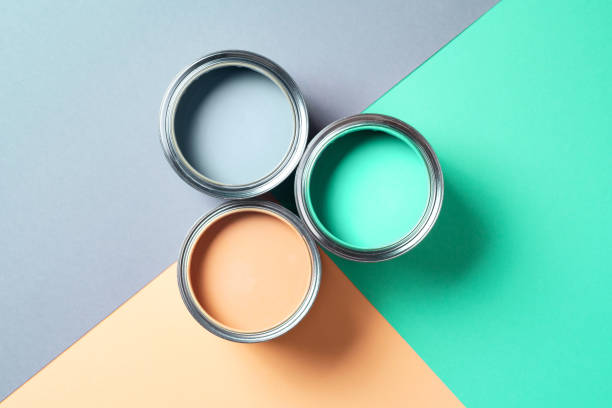 istock Open cans of paint on bright multicolored background. Top view. Copy space. Trendy green color concept 1180989976