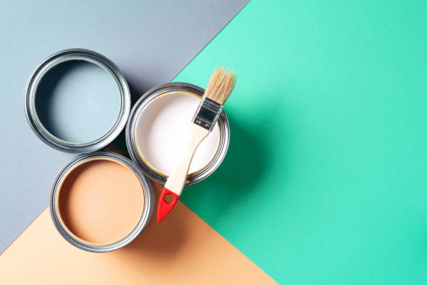 istock Metal paint cans and paint brushes on multicolor background. Top view. Copy space. Trendy green color concept 1180989983