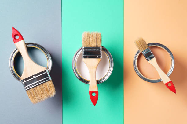 istock Metal paint cans and paint brushes on multicolor background. Top view. Copy space. Trendy green color concept 1180990000