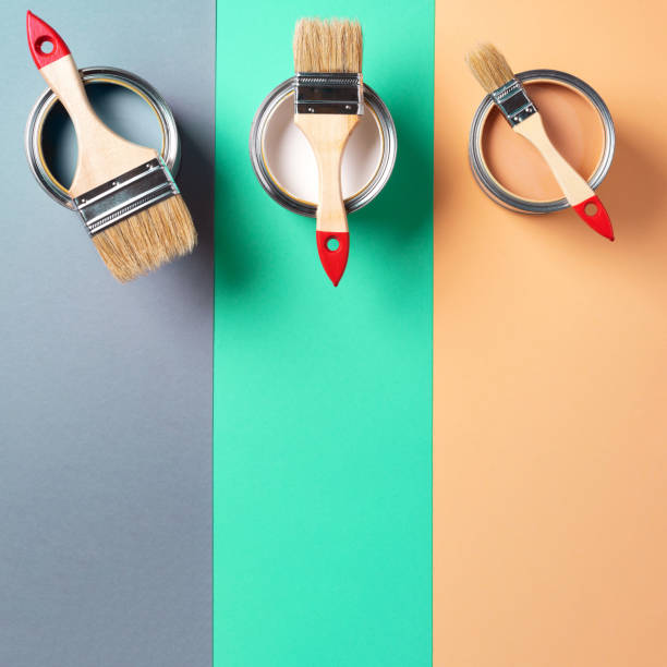 istock Metal paint cans and paint brushes on multicolor background. Top view. Copy space. Trendy green color concept 1180990019