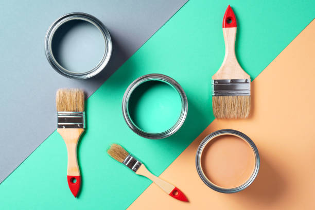 istock Metal paint cans and paint brushes on multicolor background. Top view. Copy space. Trendy green color concept 1180990036
