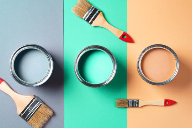 istock Metal paint cans and paint brushes on multicolor background. Top view. Copy space. Trendy green color concept 1180990065