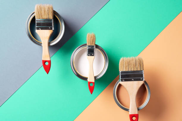 istock Metal paint cans and paint brushes on multicolor background. Top view. Copy space. Trendy green color concept 1180990082