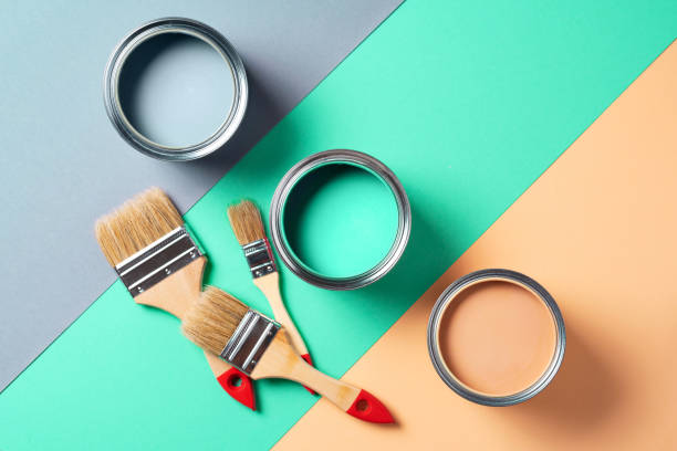 istock Metal paint cans and paint brushes on multicolor background. Top view. Copy space. Trendy green color concept 1180990117