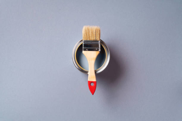 istock Brush and open paint can with on pastel background. Top view, copy space. Appartment renovation, repair, building and home design concept. 1180990148