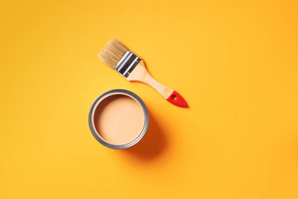 istock Brush and open paint can with on pastel background. Top view, copy space. Appartment renovation, repair, building and home design concept. 1180990190