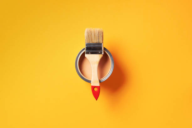 istock Brush and open paint can with on trendy yellow background. Top view, copy space. Appartment renovation, repair, building and home design concept. 1180990210