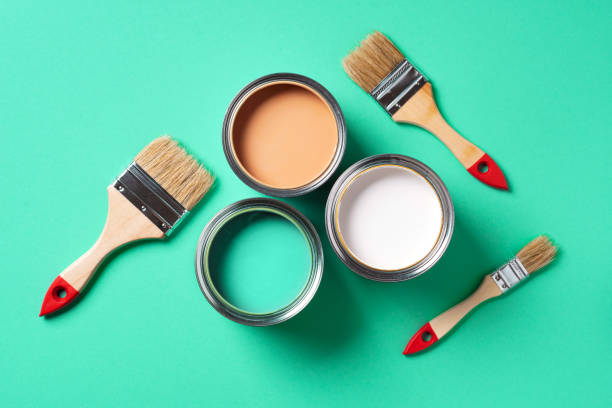 istock Paint brushes and open paint cans with on trendy green background. Top view, copy space. Appartment renovation, repair, building and home design concept. 1180990223