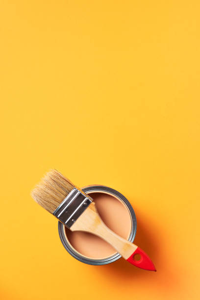 istock Brush and open paint can with on trendy yellow background. Top view, copy space. Appartment renovation, repair, building and home design concept. 1180991021