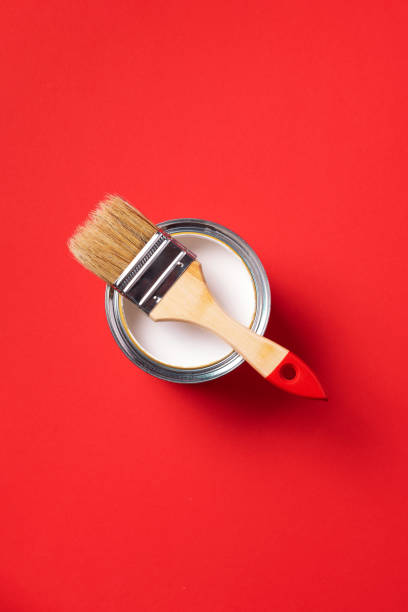 istock Brush and open paint can on trendy red background. Top view, copy space. Appartment renovation, repair, building and home design concept. 1180991113