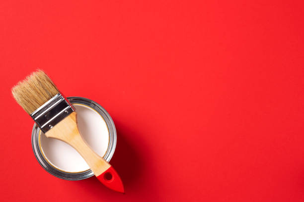 istock Brush and open paint can on trendy red background. Top view, copy space. Appartment renovation, repair, building and home design concept. 1180991140