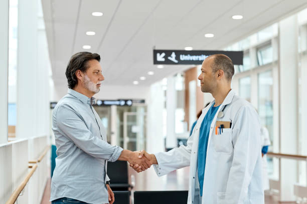 istock Doctor Shaking Hands With Patient In Waiting Room 1180992433