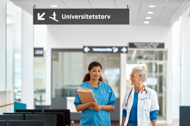istock Doctor And Nurse Talking In Waiting Room 1180992450