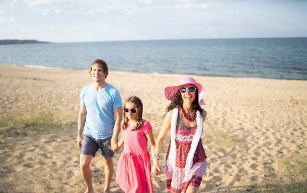 istock Happy family enjoying summer vacations on beach 1180992763