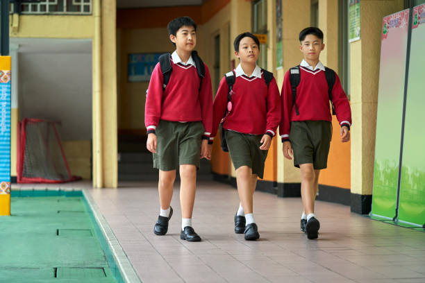 istock Schoolboys walking together in school corridor 1180994842