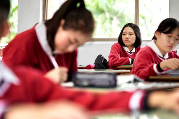 istock Thoughtful schoolgirl sitting at desk in classroom 1180994877