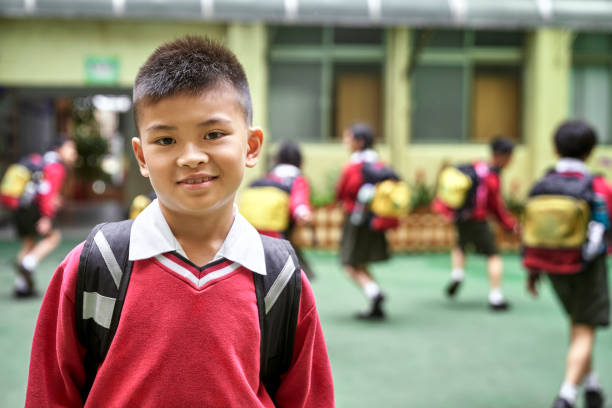 istock Portrait of cute schoolboy with backpack in school 1180994921