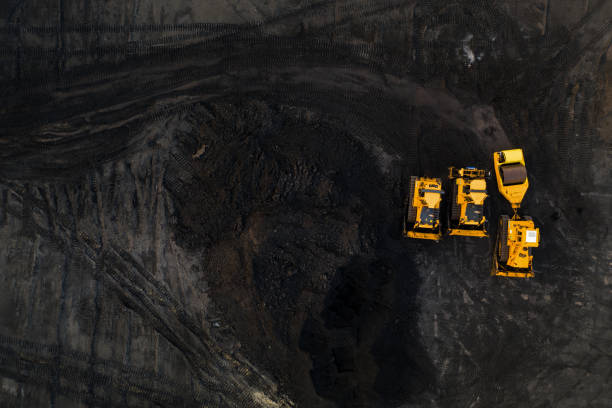 istock Top down view on yellow excavators in coal storage. 1180996388