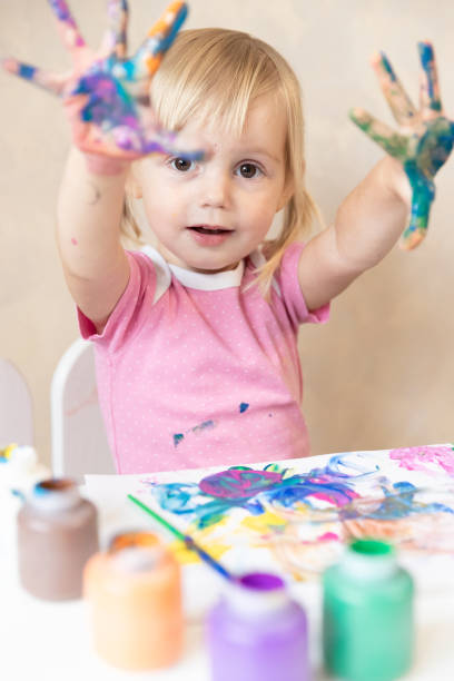 istock Little Child Draws Painted Hands in Paint. Painting. Development and Training 1180998329