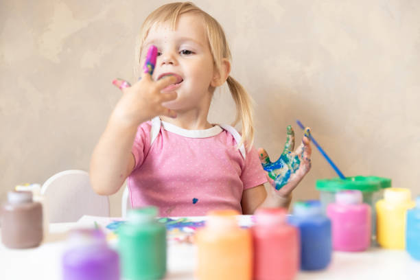 istock Little Child Draws Painted Hands in Paint. Painting. Development and Training 1180998335