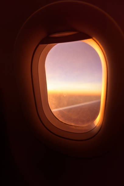 istock plane window ,beautiful sunset on the plane warm tone sunset 1180998635