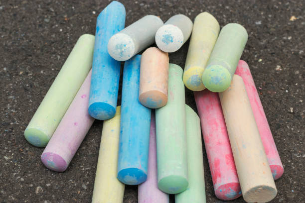 istock Multi-colored crayons for drawing lie like a rainbow next to the asphalt background 1181001608