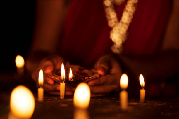 istock Woman Lighting Up Candles on Diwali 1181004281