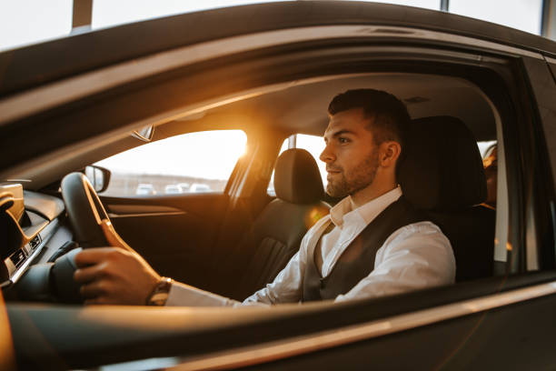istock Successful well dressed young man driving his new car 1181004490