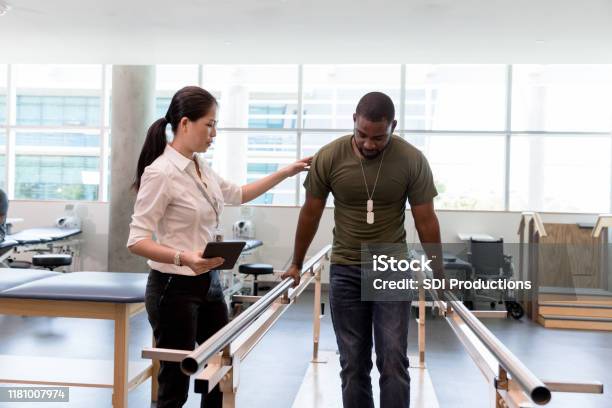 Physical Therapist Guides Military Vet As He Uses Injured Foot Stock Photo - Download Image Now