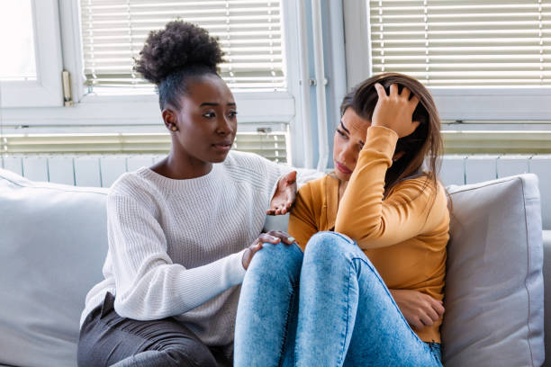 istock Sad girl and supporting friends trying to solve a problem. Two sad diverse women talking at home. Female friends supporting each other. Problems, friendship and care concept 1181008095